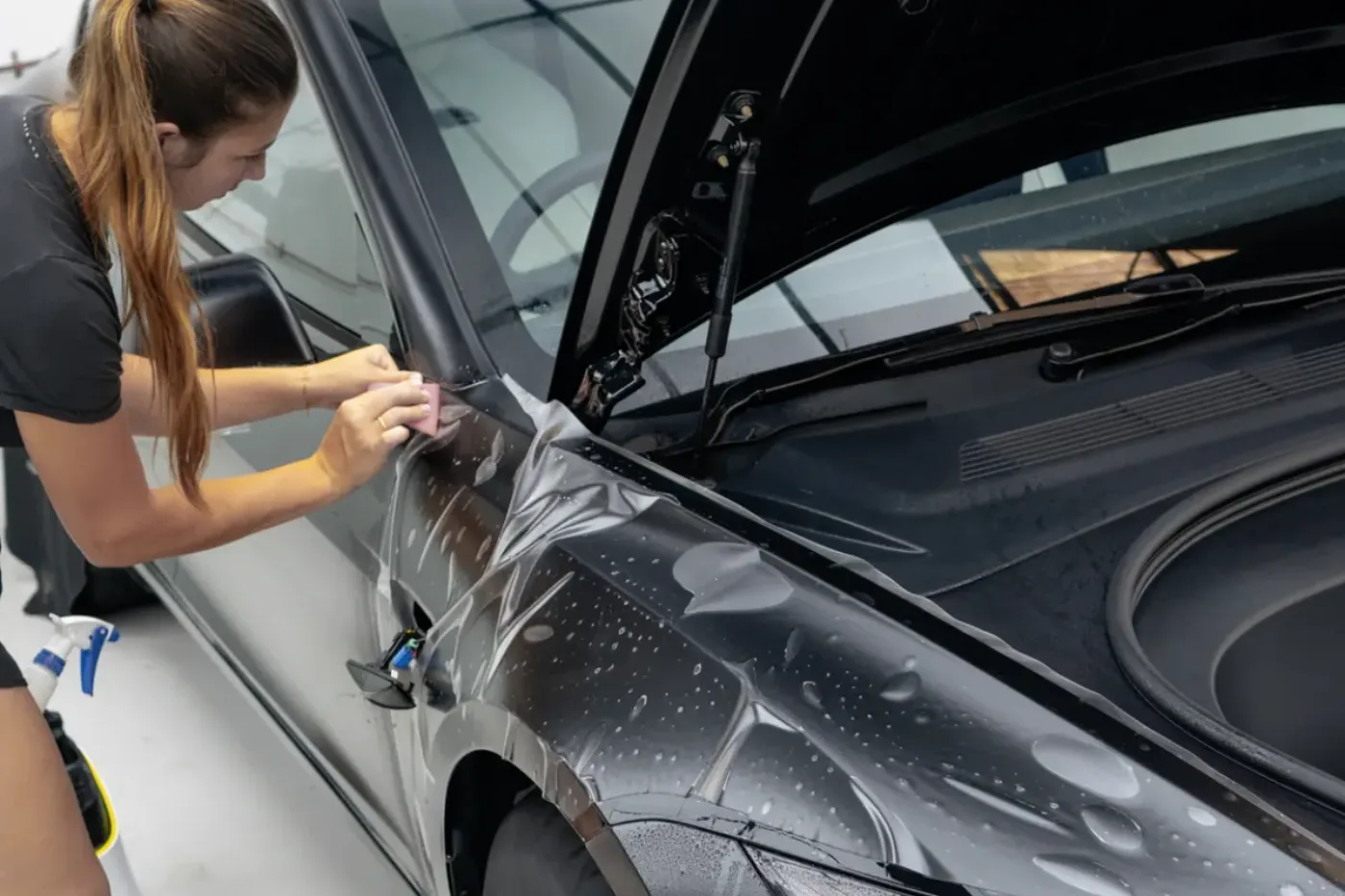 Paint protection film being applied to the front of a car