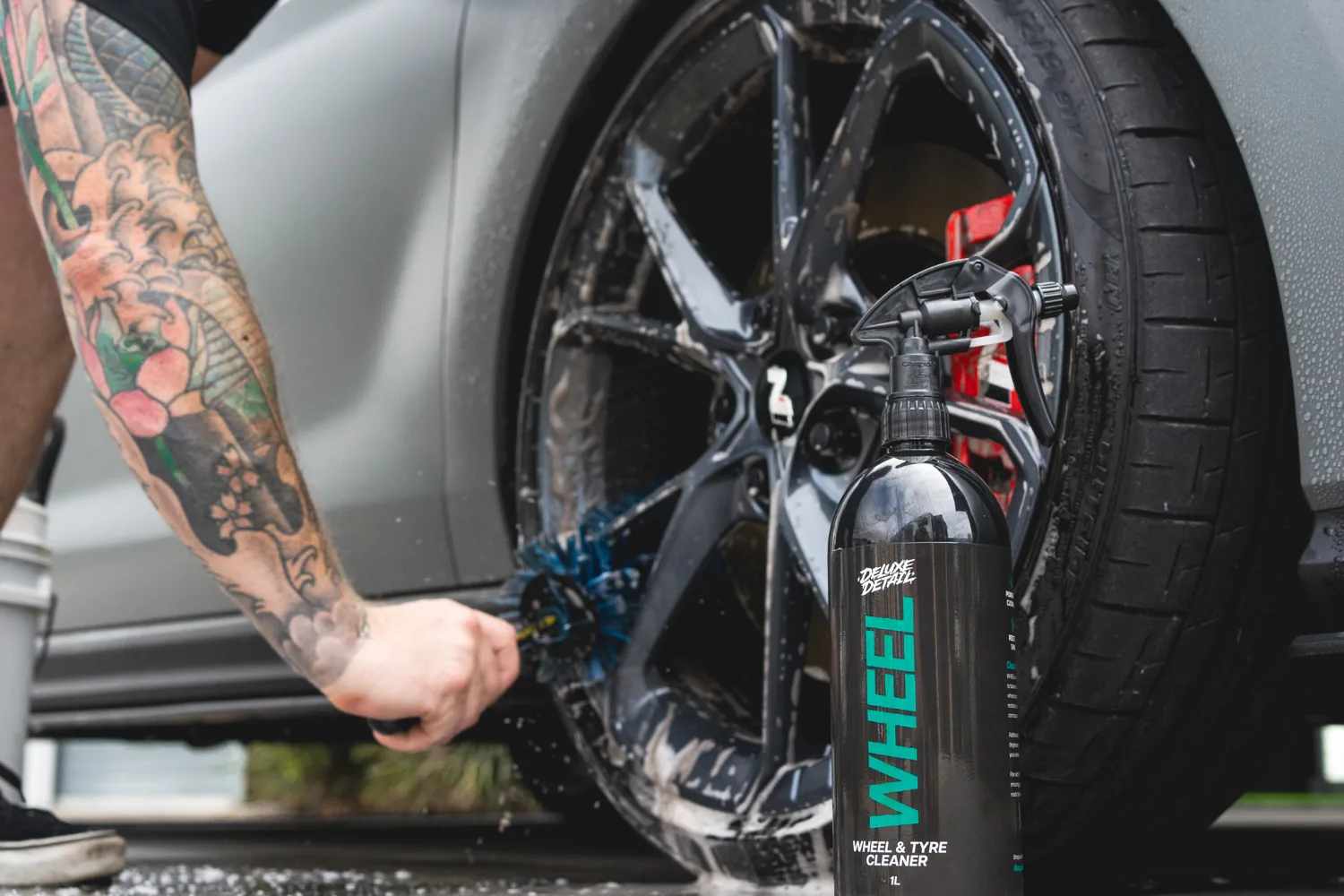 Cleaning a wheel with a dedicated brush and wheel cleaner, kept separate from the paint wash equipment